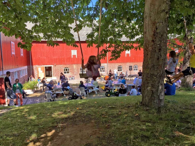 Ungar og vaksne utanfor Landbruksmuseet på Gjermundnes.